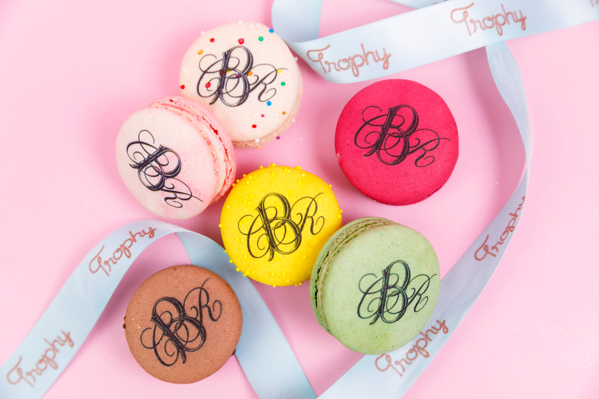 Macarons printed with a monogram, tied with a Trophy ribbon