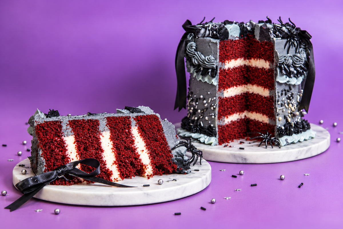 A slice of Trophy's vintage Halloween cake beside the cake on a purple background