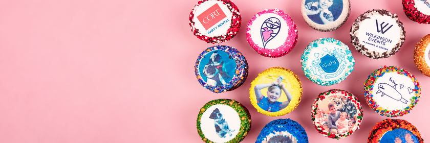 Trophy cupcakes printed with logos, a child's drawing and family photos, on a pink background