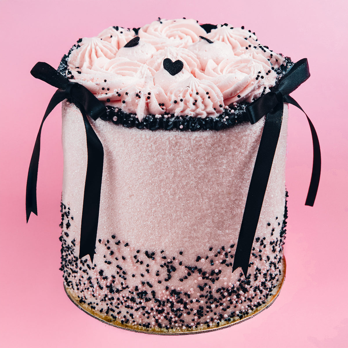 A Trophy Valentine's cake wrapped in black ribbon bows