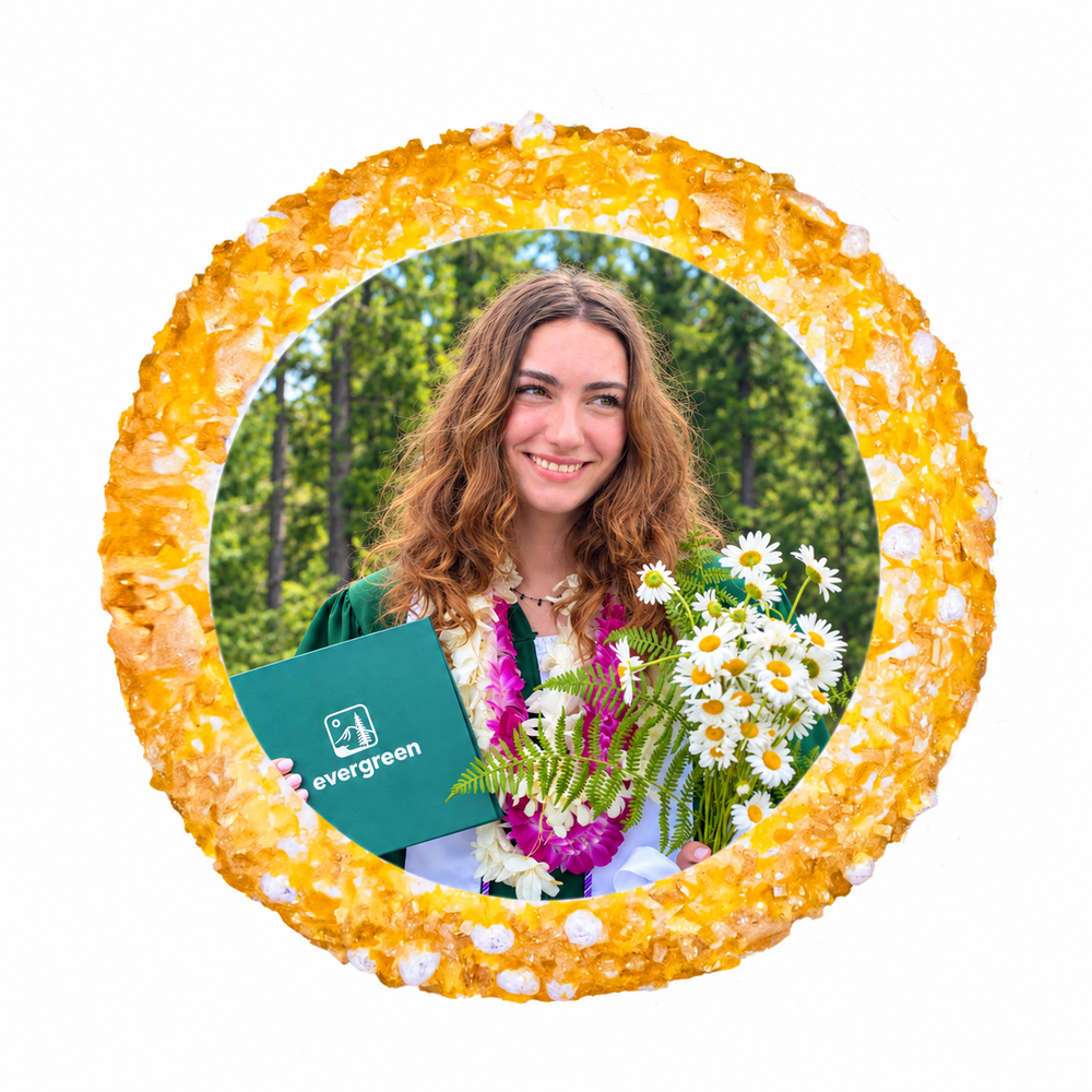 Graduation photo cupcake with a gold sugar border and a graduate holding an Evergreen diploma and flowers