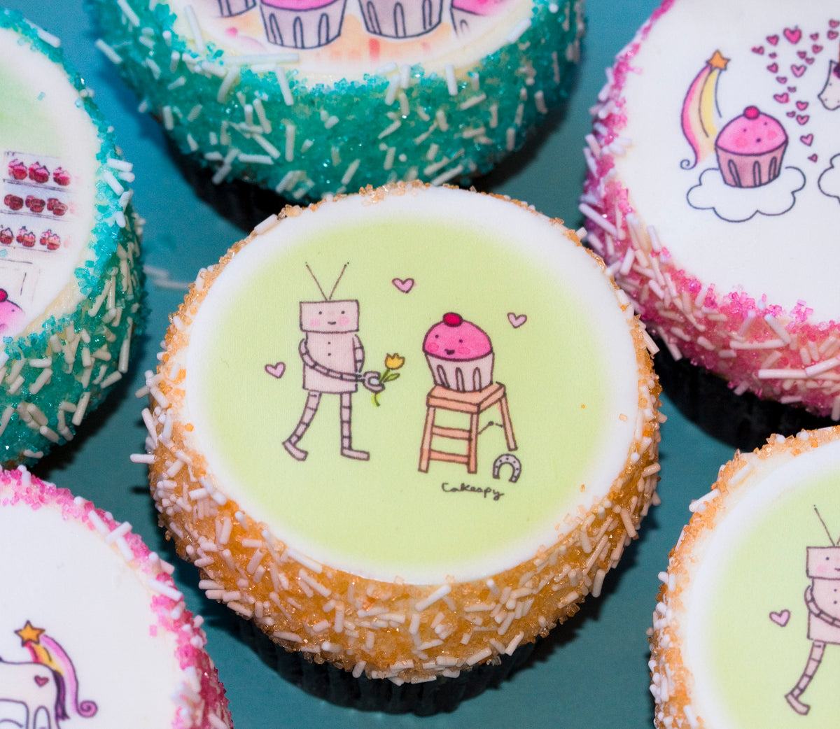 Custom Photo Cupcakes with printed cartoon drawings of a robot and a cupcake and sprinkle borders