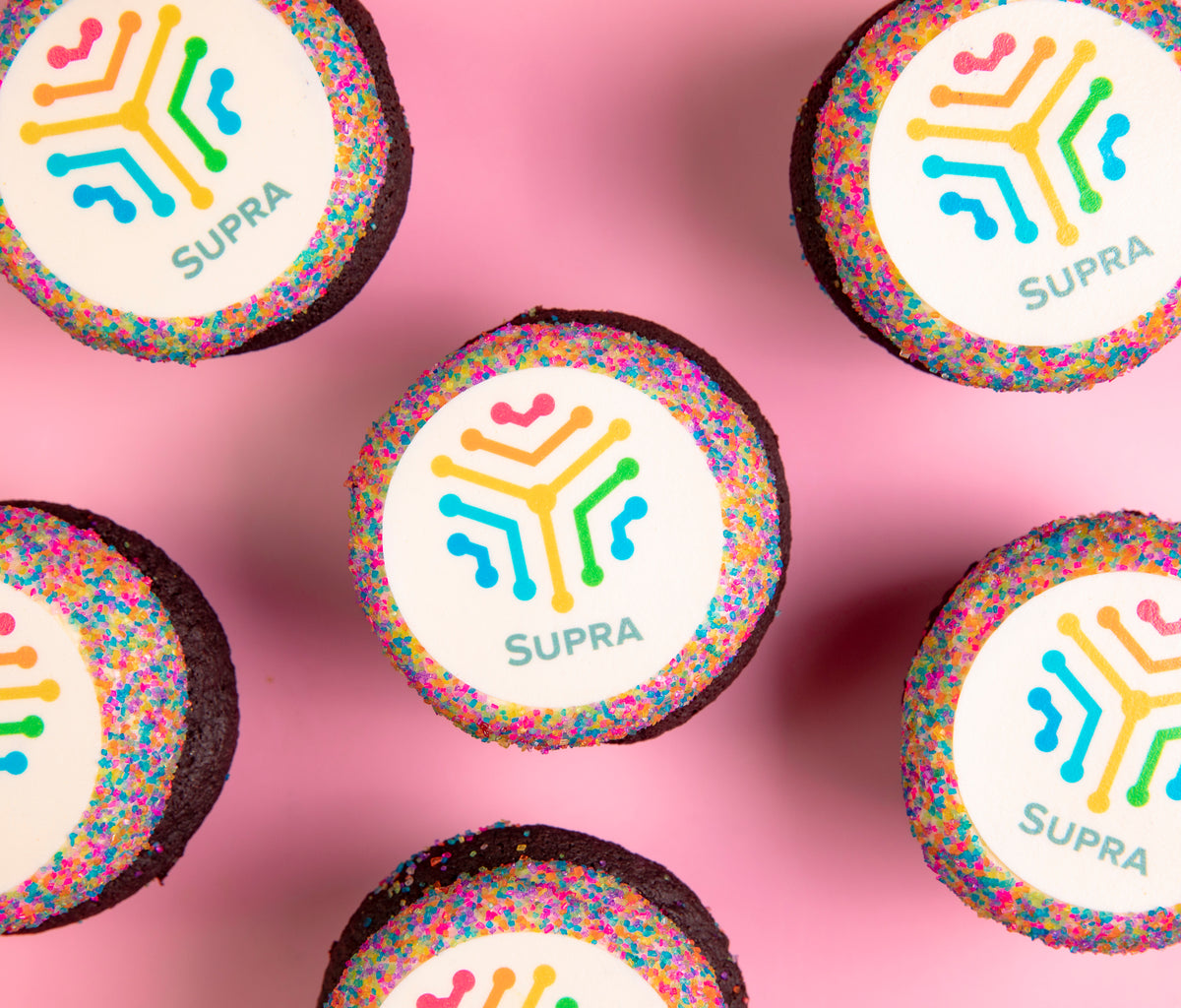Custom Photo Cupcakes with printed company logo images on sprinkle-edged chocolate cupcakes, overhead