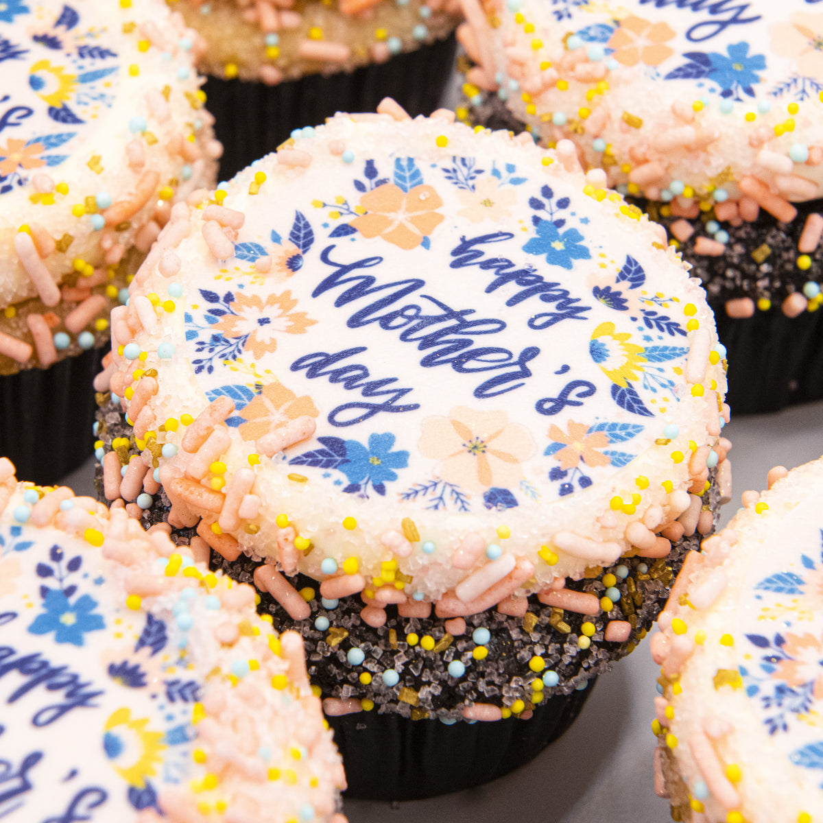 A cupcake topped with a floral Happy Mother’s Day print