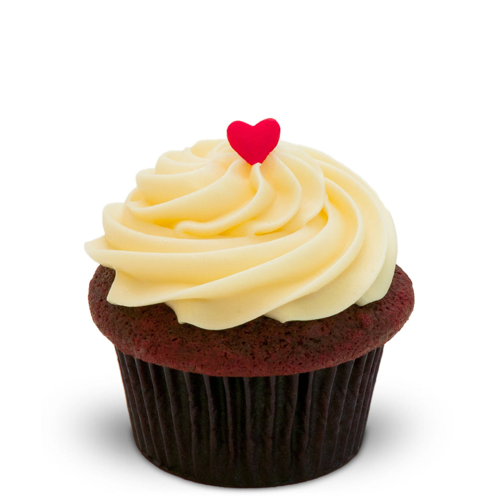 Red Velvet cupcake with a swirl of cream cheese frosting and a red candy heart on a white background